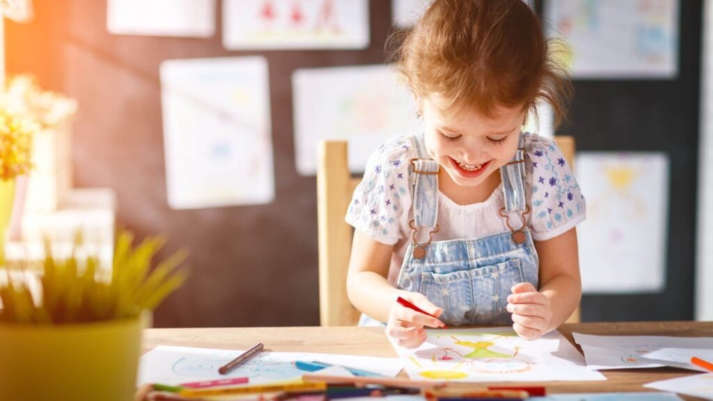 کودک در حال نقاشی با مداد رنگی در فضای امن خانه